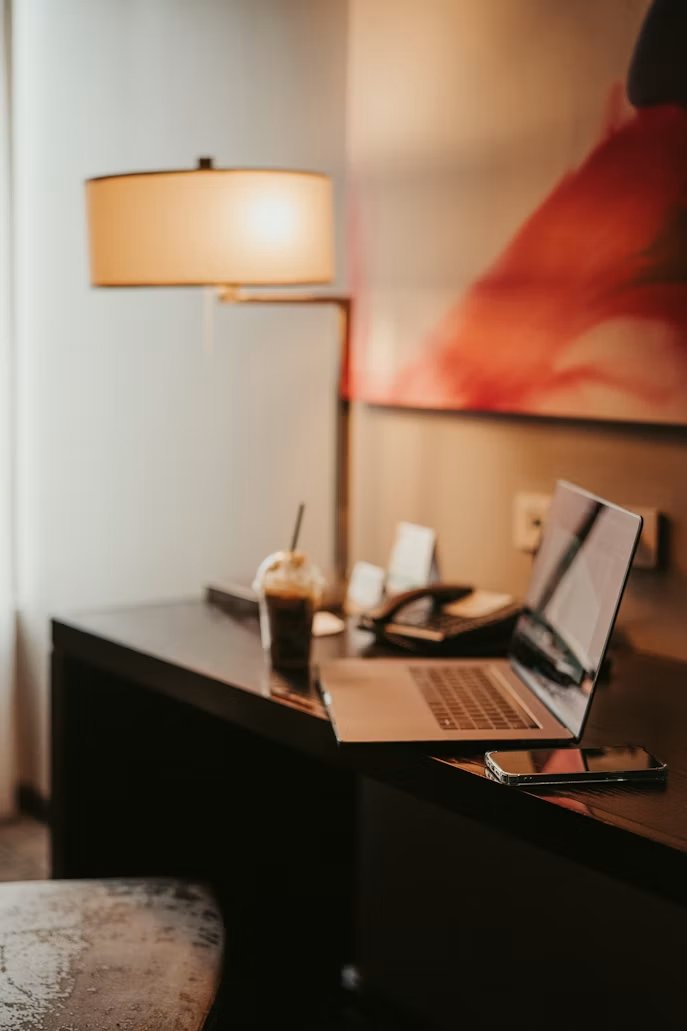 Hotel room desk with laptop and phone